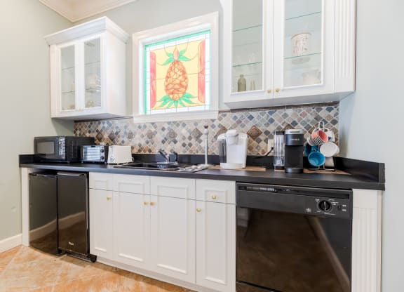 a kitchen with white cabinets and a black counter top at Heritage Bay, Jensen Beach, FL 34957