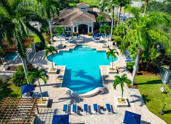a large swimming pool with a house in the background at Heritage Bay, Jensen Beach, FL 34957
