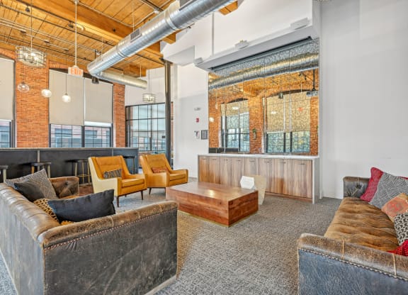 a living room with couches and chairs and a table at Riverwalk Apartments, Lawrence, MA