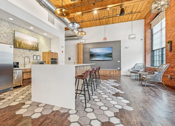 a kitchen with a white island and bar stools at Riverwalk Apartments, Lawrence, MA