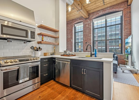 a kitchen with stainless steel appliances and a large window at Riverwalk Apartments, Lawrence, MA