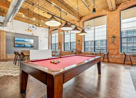 a pool table in an office space with a red pool table at Riverwalk Apartments, Lawrence, MA