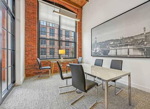 a conference room with a table and chairs and a large window at Riverwalk Apartments, Lawrence, MA