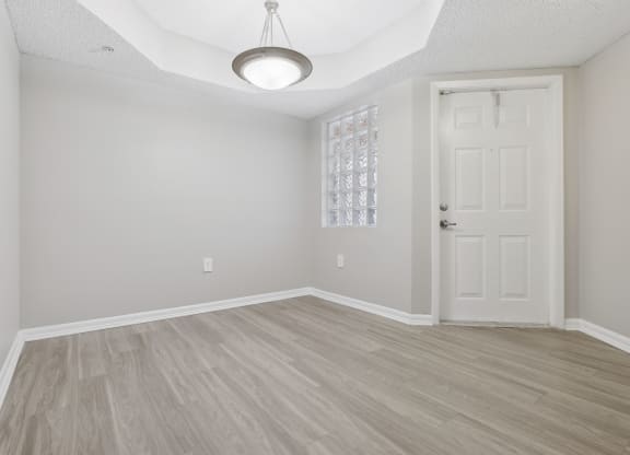 an empty living room with a white door and wood flooring at Pembroke Pines Landings, Pembroke Pines
