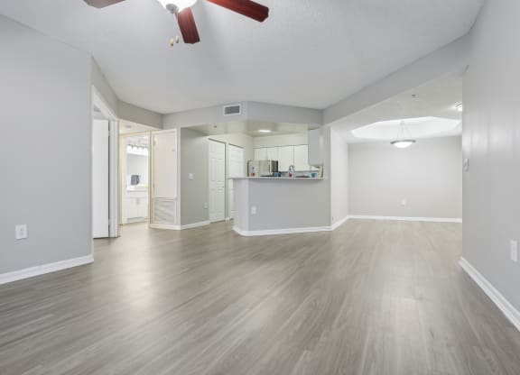 the living room and kitchen of an empty house with wood floors and a ceiling fan at Pembroke Pines Landings, Florida, 33025