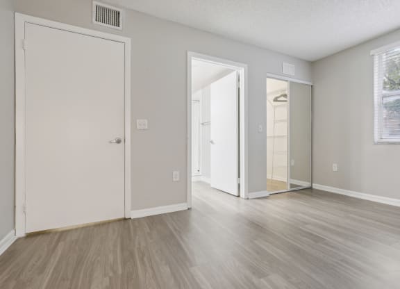 the living room of an apartment with white walls and wood floors at Pembroke Pines Landings, Pembroke Pines, FL 33025
