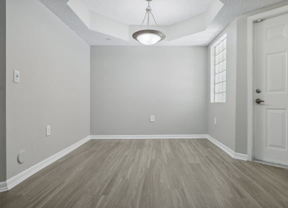 an empty living room with a white door and wood flooring at Pembroke Pines Landings, Florida, 33025