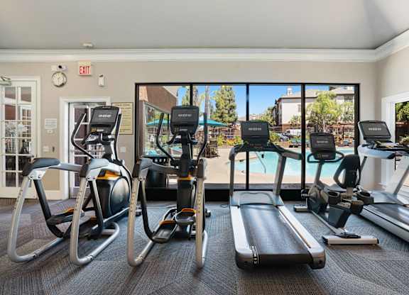 A gym with treadmills, elliptical machines, and stationary bikes.