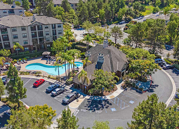 A large apartment complex with a pool and a parking lot.