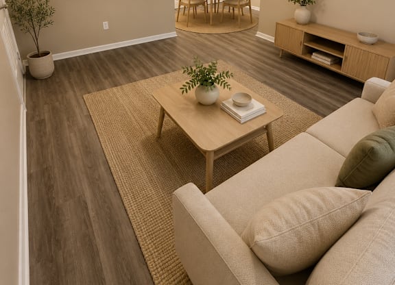 A living room with a couch, a table, and a potted plant.