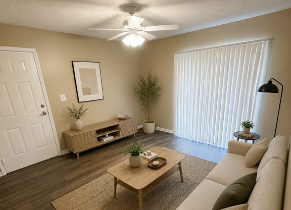 A living room with a couch, coffee table, and a ceiling fan.