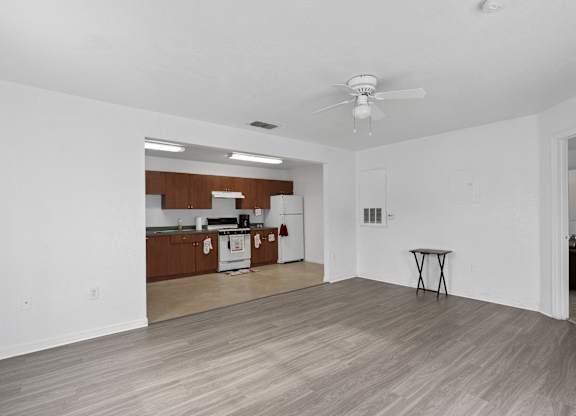 living room with a ceiling fan and a kitchen at The Groves at Wimauma Apartments , Wimauma, 33598