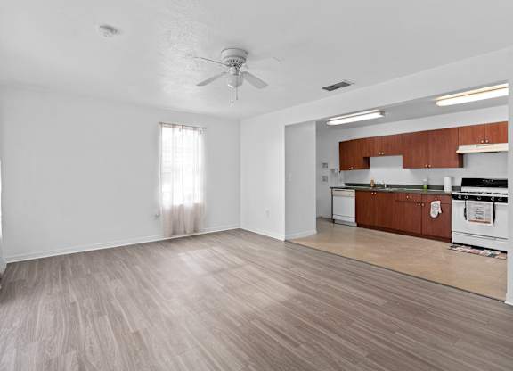 an empty living room and kitchen with a ceiling fan at The Groves at Wimauma Apartments , Wimauma, FL