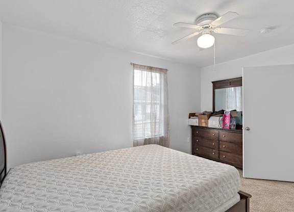 an empty bedroom with a bed and a ceiling fan at The Groves at Wimauma Apartments , Wimauma, FL, 33598