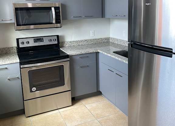 a kitchen with gray cabinets and stainless steel appliances at Colonial Drive Apartments, Orlando, FL 32808
