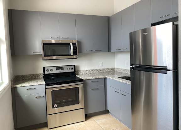 a kitchen with gray cabinets and stainless steel appliances at Colonial Drive Apartments, Florida