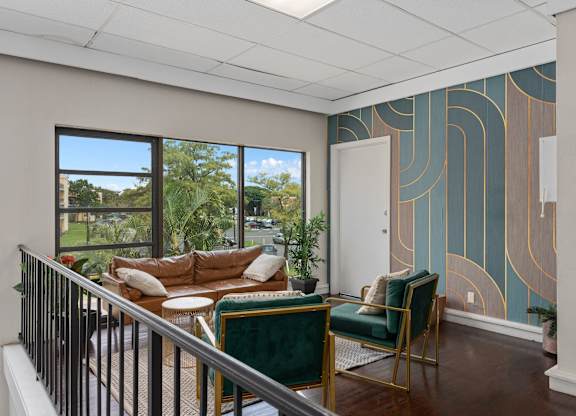a living room with a couch and chairs on a balcony  at Cypress Grove, Lauderhill, FL