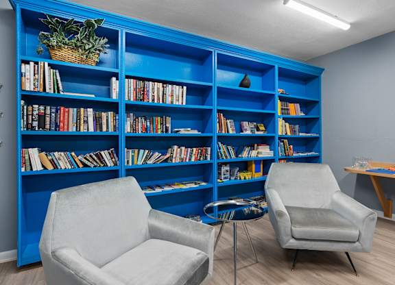 two chairs in front of a blue bookshelf at Cypress Grove, Lauderhill, 33313