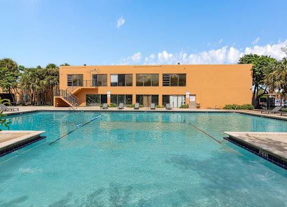 a swimming pool with a building in the background at Cypress Grove, Lauderhill, 33313