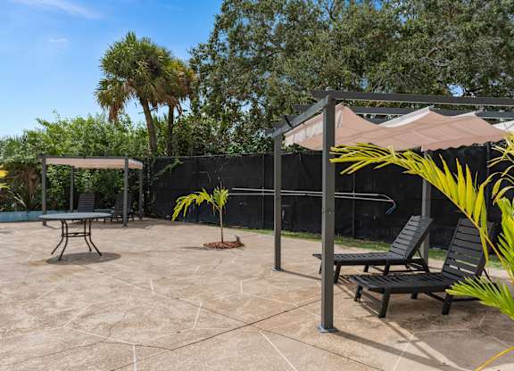 a patio with two chairs and a canopy at Cypress Grove, Lauderhill, FL
