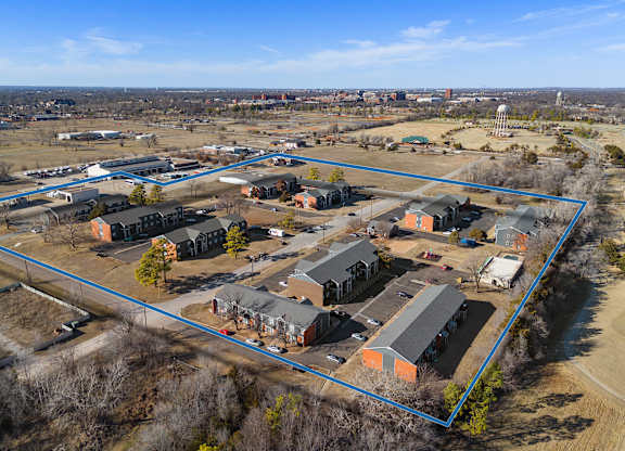 a birdseye view of a neighborhood of houses and a city in the background at Emerald Greens, Norman, 73072