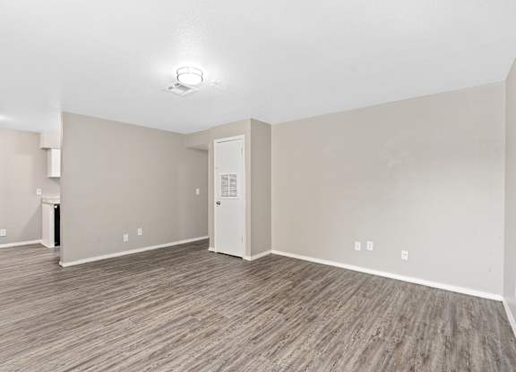 an empty room with white walls and a wood floor at Emerald Greens, Norman, 73072