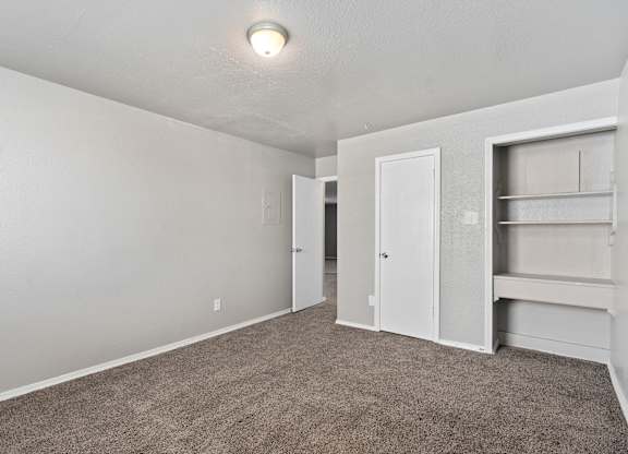 an empty room with carpet and a closet at Emerald Greens, Norman Oklahoma