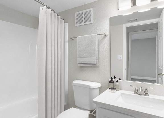 a white bathroom with a shower and a toilet and a sink at Lakeside Villas, Orlando, FL