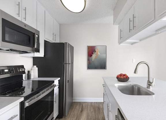 a kitchen with black appliances and white cabinets at Lakeside Villas, Florida