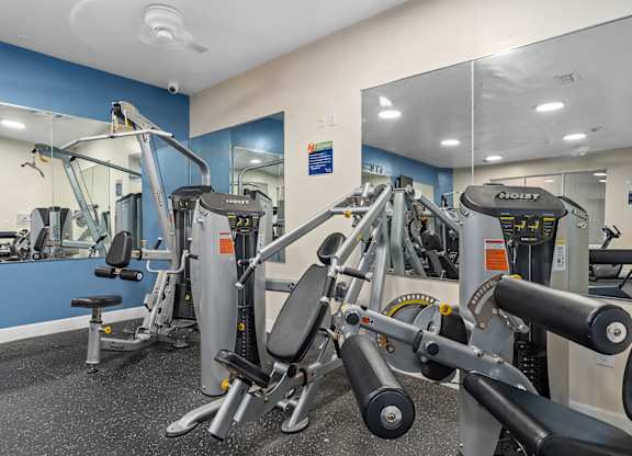 a gym with exercise equipment and mirrors in a building at Lake Lofts at Deerwood, Jacksonville, FL