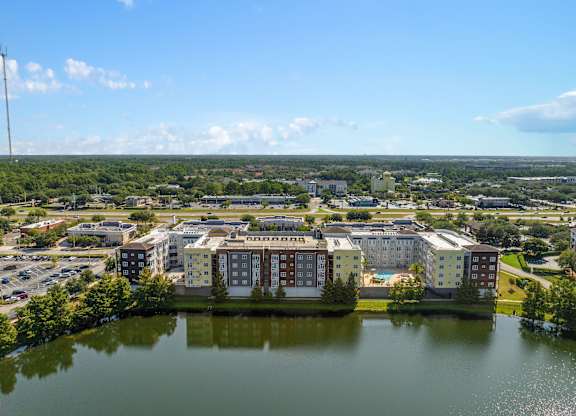 an aerial view of apartment buildings near a body of water at Lake Lofts at Deerwood, Jacksonville
