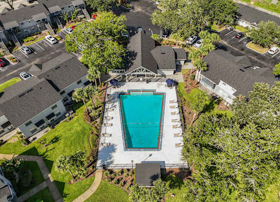 a birds eye view of a swimming pool in a neighborhood with houses and trees at Oak Reserve at Winter Park, Winter Park