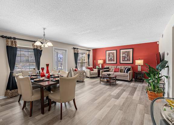 a living room and dining room with red walls and wooden floors at Oak Reserve at Winter Park, Winter Park, 32792