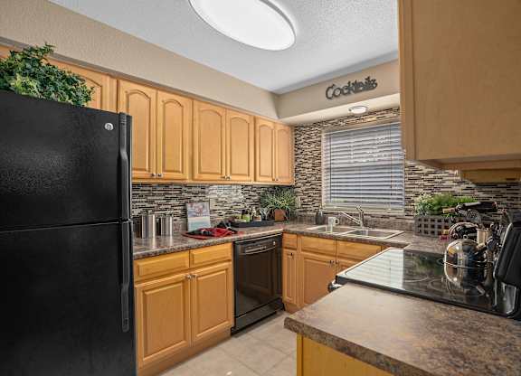 a kitchen with black appliances and wooden cabinets at Oak Reserve at Winter Park, Florida, 32792