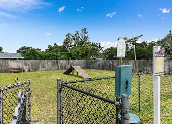 a park with a chain link fence and a seesaw in the grass at Oak Reserve at Winter Park, Winter Park, FL