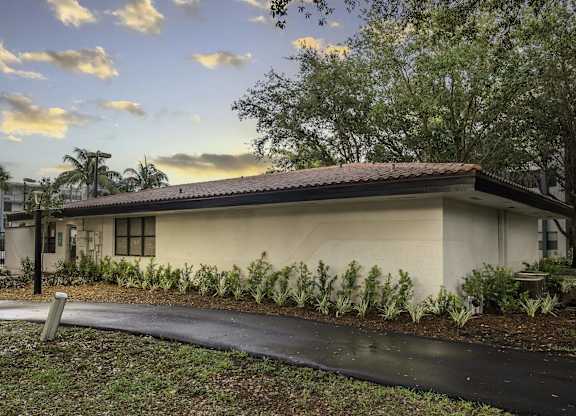a house with a driveway and trees in the background  at Club at Emerald Waters, Hollywood, 33021