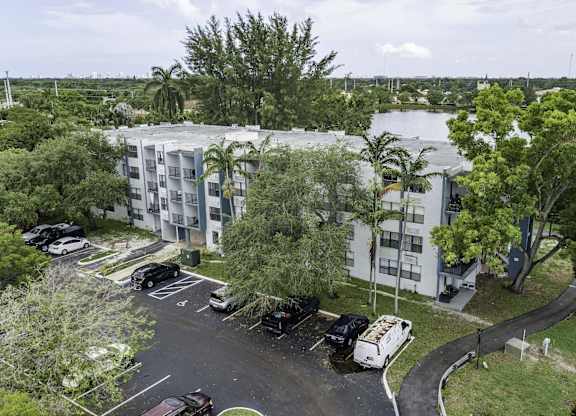 an aerial view of a large white apartment complex with a river in the background  at Club at Emerald Waters, Hollywood, 33021
