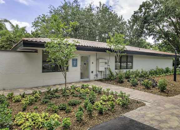 a white house with a garden in front of it  at Club at Emerald Waters, Hollywood, Florida