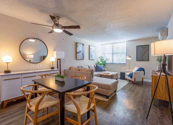 a living room and dining area with a ceiling fan and a large mirror  at Club at Emerald Waters, Hollywood, FL