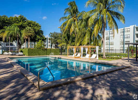a swimming pool with palm trees in the background  at Club at Emerald Waters, Hollywood, FL
