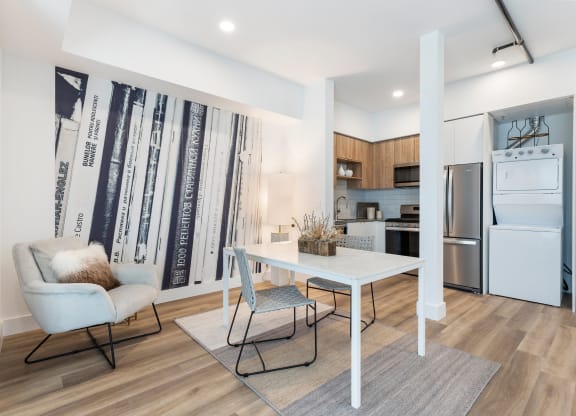 Dining room area with a white marble table and gray seating with a contemporary wall backspalsh.