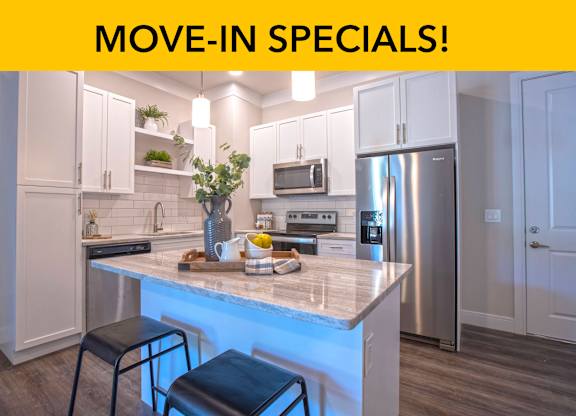 A modern kitchen with a marble countertop and stainless steel appliances.