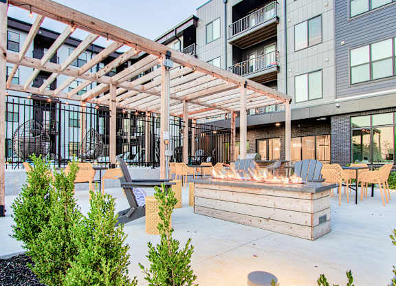 A wooden pergola is over a fire pit on a patio.at Bold on the Blvd, St. Peters, MO 63376