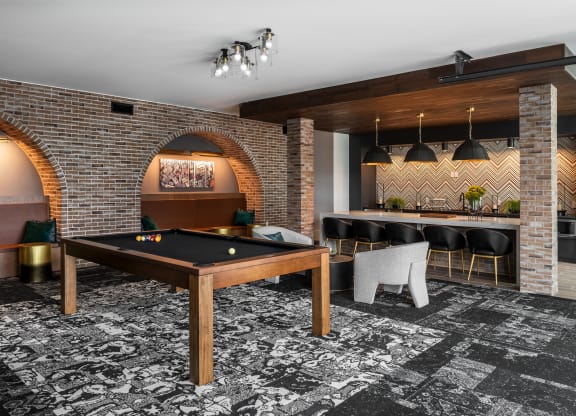 Modern resident clubroom with pool table and lounge kitchen  at Chapter at the Streets of St Charles, Saint Charles, MO, 63303