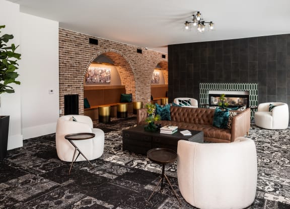 Modern resident lounge with exposed brick, rich design and conversational seating  at Chapter at the Streets of St Charles, Missouri