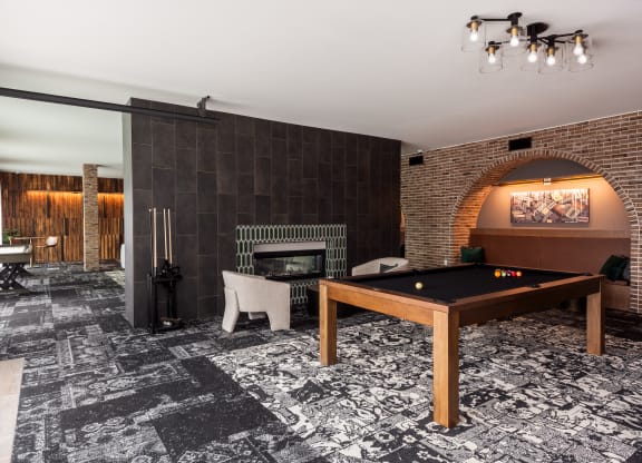 Modern resident clubroom with pool table and pass through fireplace  at Chapter at the Streets of St Charles, Saint Charles