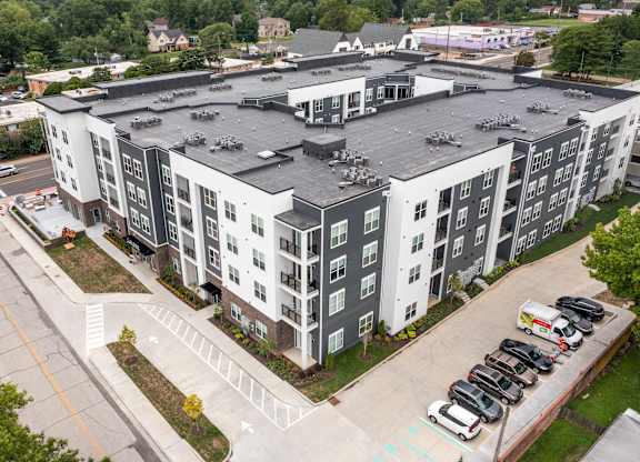 A large apartment complex with a parking lot in front at The Oliver Apartments, Olivette, Missouri