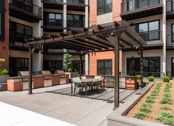 Resident courtyard with grilling stations, outdoor refrigerators, pergola and seating  at Chapter at the Streets of St Charles, Saint Charles, MO