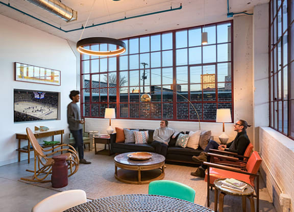 Steelcote Lofts clubroom with conversational seating, TV and oversized windows  at Steelcote Square, St. Louis, MO