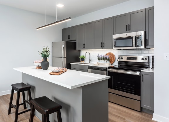 model kitchen with stainless steel appliances, plank flooring, kitchen island and at Steelcote Square, St. Louis, MO, 63103